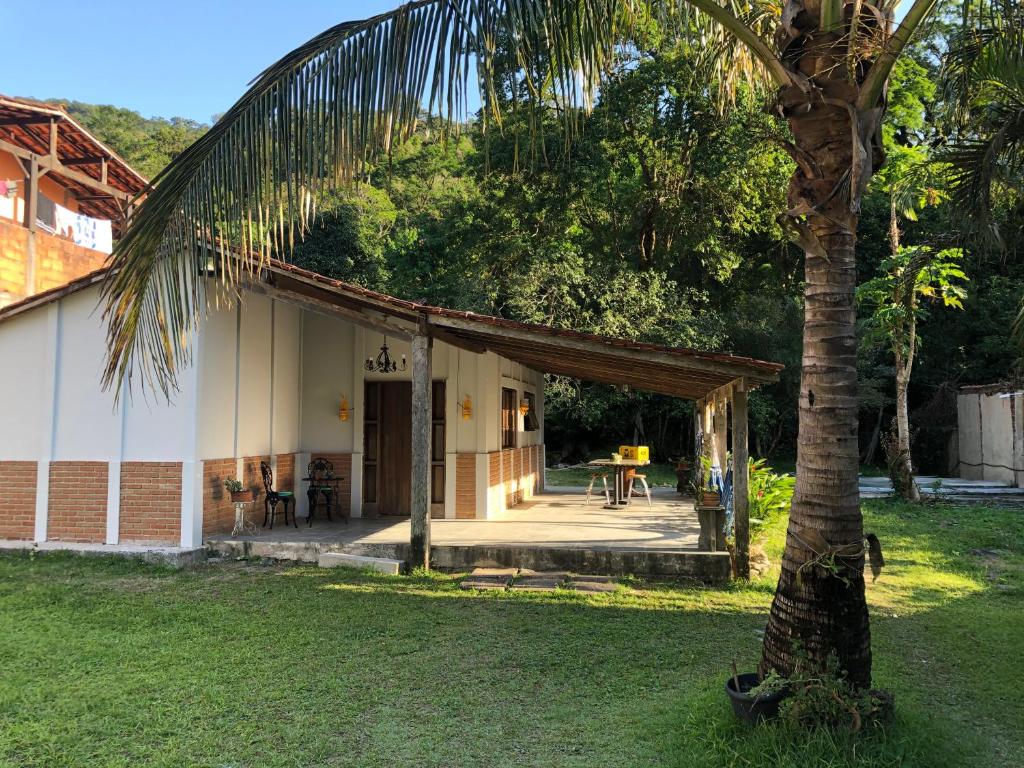 a house with a palm tree in the yard at Casa de praia em Paúba perto de cachoeira e 5min de Maresias in Pauba