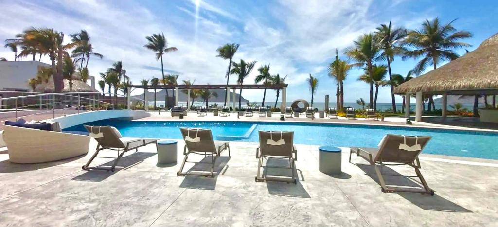 um grupo de cadeiras sentadas ao lado de uma piscina em Camino Al Mar with Amazing View of the Ocean, Beach and Pool em Mazatlán