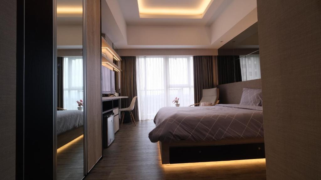 um quarto de hotel com uma cama e um espelho em Bella Casa, Apt Casa de Parco closed to AEON and ICE BSD em Samporo
