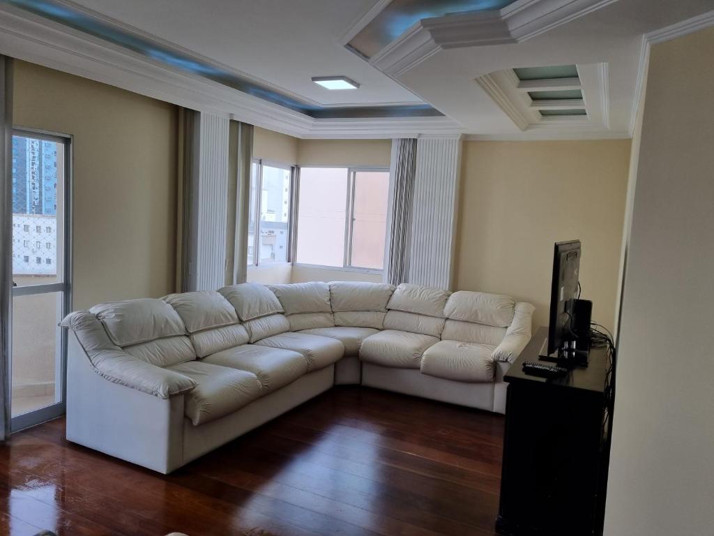 a living room with a white couch in a room at Apto Av Brasil Quadra mar in Balneário Camboriú