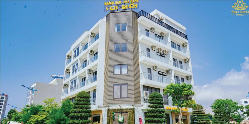 un edificio blanco alto con un letrero. en Hệ Thống Sen Biển Hotel FLC Sầm Sơn - Restaurant Luxury en Sầm Sơn