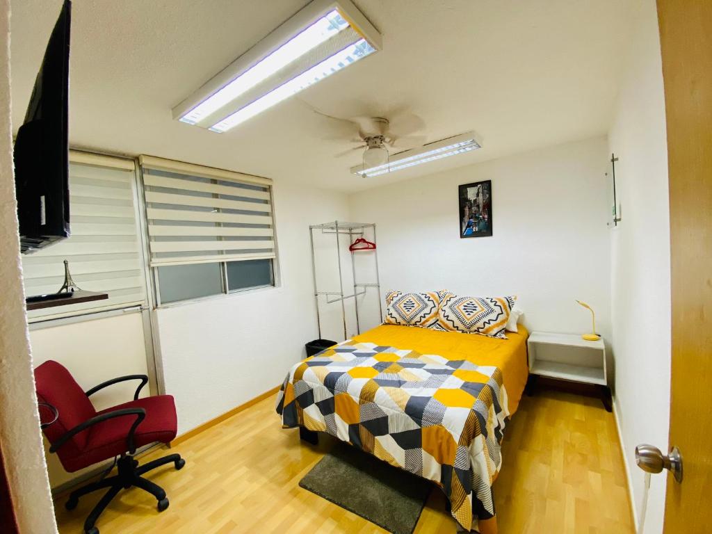 1 dormitorio con 1 cama y 1 silla roja en Cómodo y Pintoresco Depa Al sur de La Ciudad! en León