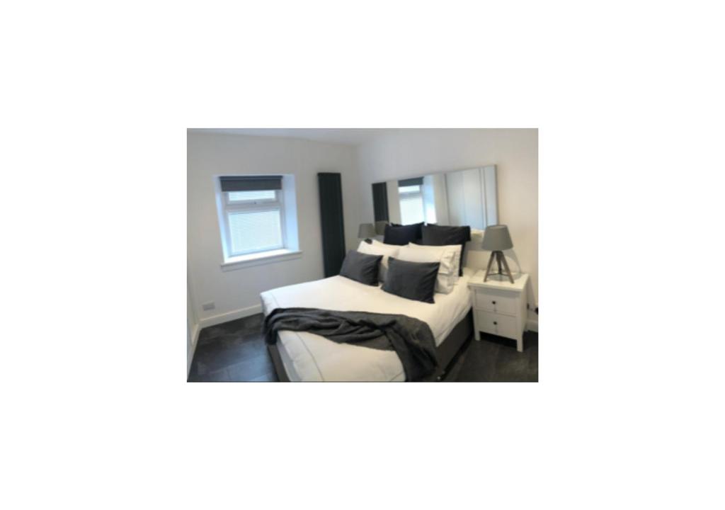 印威內斯的住宿－Grey Apartment，一间卧室配有一张带黑白枕头的床