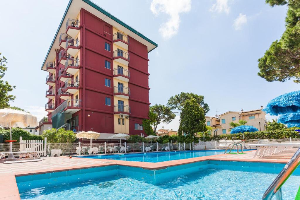 un hotel con piscina frente a un edificio en Hotel Frank, en Lido di Jesolo