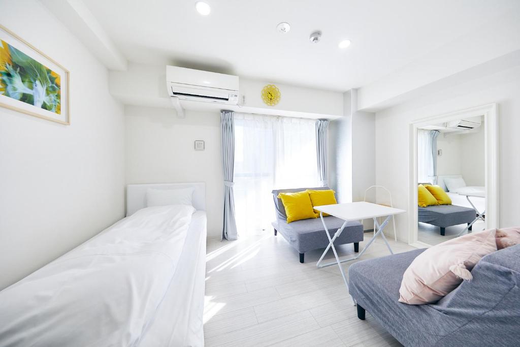 1 dormitorio con cama, sofá y mesa en Montana Flat Yebisu en Osaka