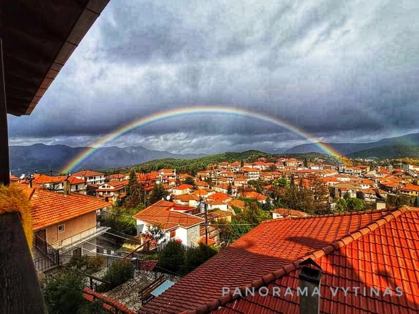 un arcobaleno su una città con tetti rossi di Panorama Vytinas a Vytina