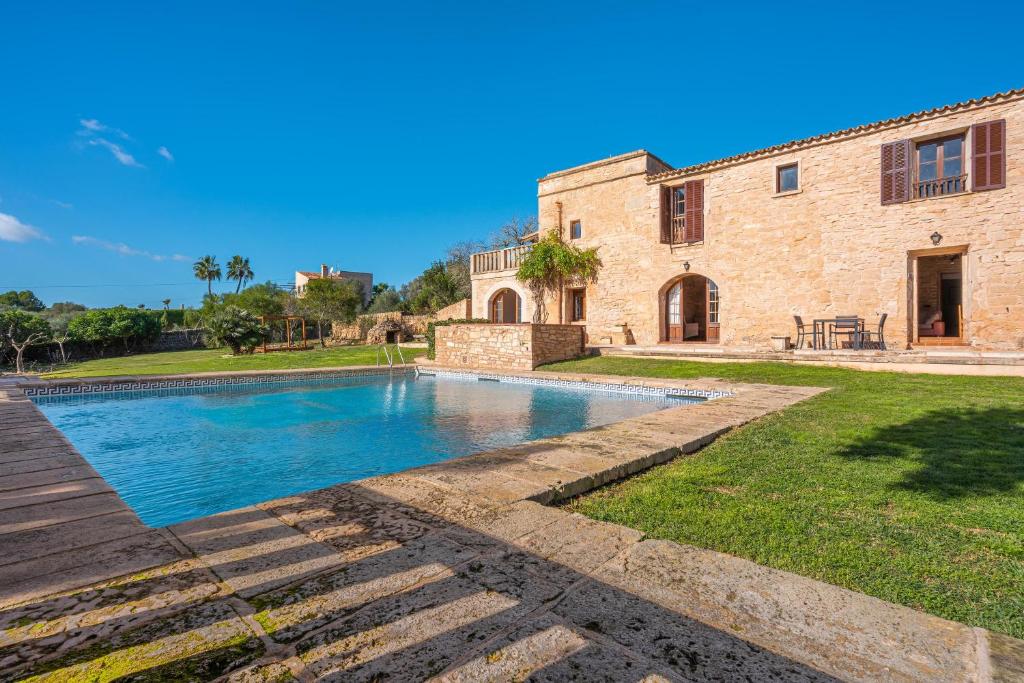 una casa con piscina frente a un edificio en Es turo de Menorca, en Ses Salines