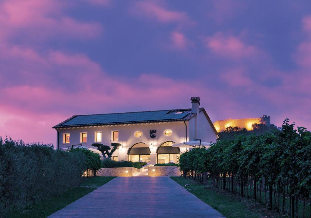 une maison blanche avec un chemin en face d'un bâtiment dans l'établissement Progress Country & Wine House, à Asolo