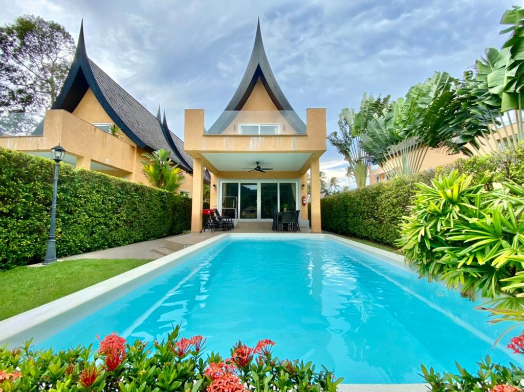 a swimming pool in front of a house at Laguna Pearl Private Pool Villa - Koh Chang in Ko Chang