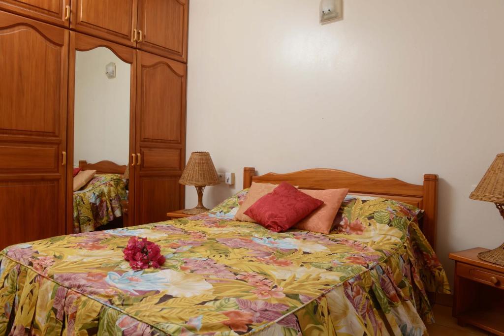 a bedroom with a bed with flowers on it at Pension de famille HITI MOANA VILLA in Papara