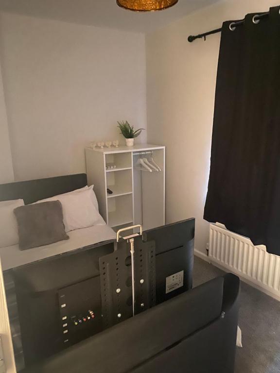 a living room with a couch and a bed at Stylish & Convenient in Belfast