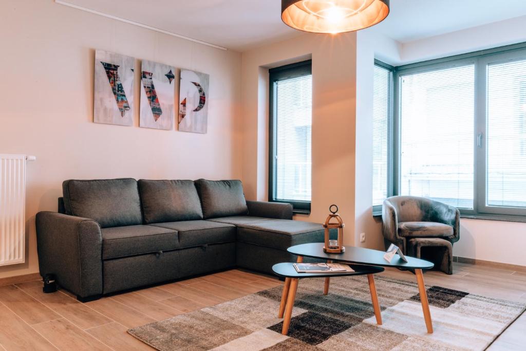 a living room with a couch and a table at Appartementen by WP Hotels in Blankenberge