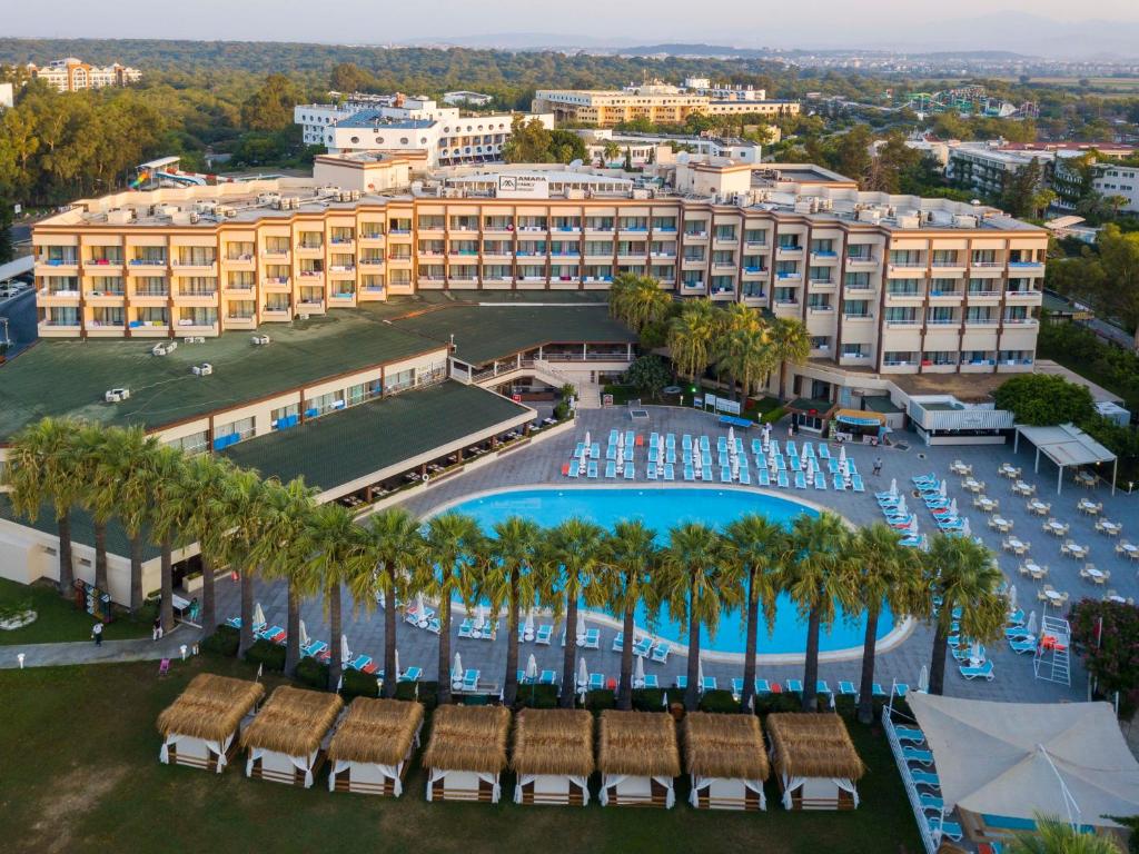 an aerial view of a resort with a pool and palm trees at Amara Family Resort in Side