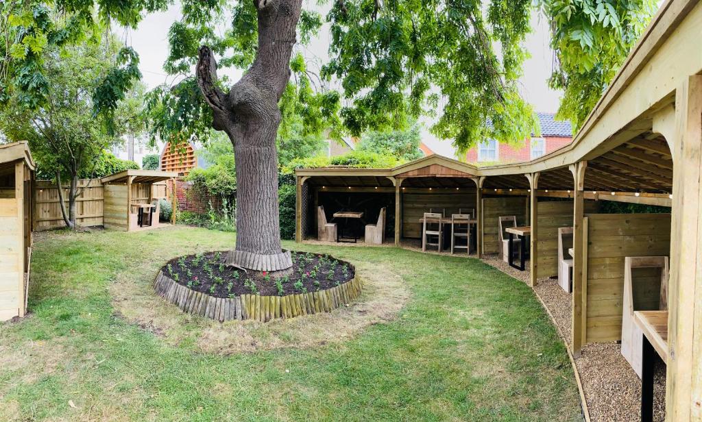 a tree in a yard next to a building at Sutherland House in Southwold
