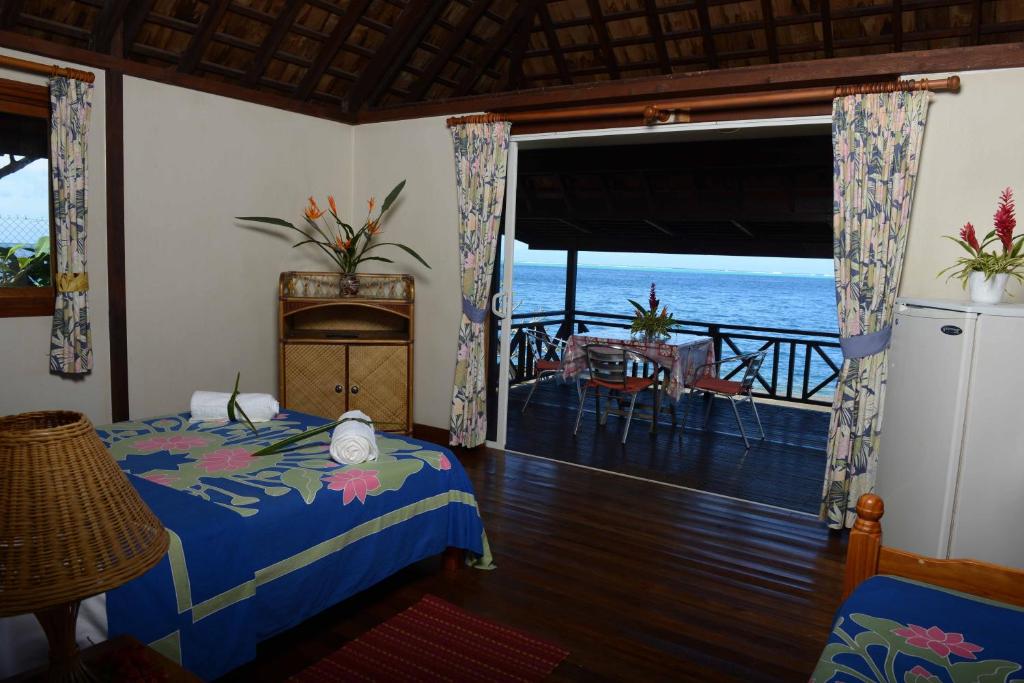 a bedroom with a bed and a view of the ocean at Pension de famille HITI MOANA VILLA in Papara