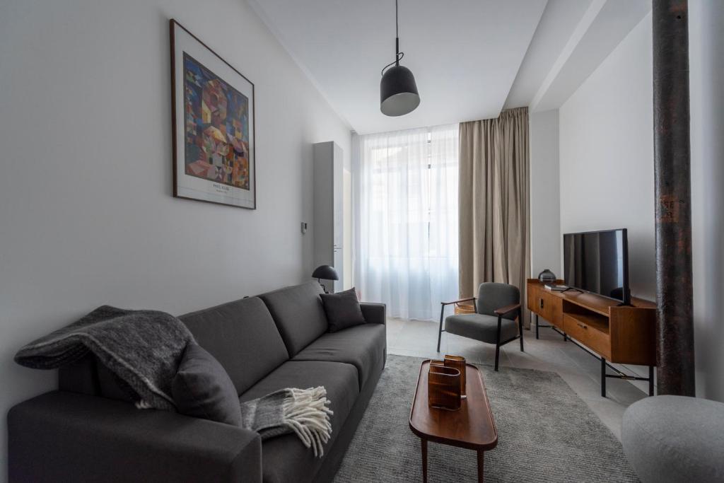 un salon avec un canapé et une télévision dans l'établissement Denver, à Paris