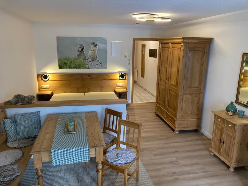 een woonkamer met een houten tafel en stoelen bij Murmelschlupf & Hummelschlupf in Oberstaufen