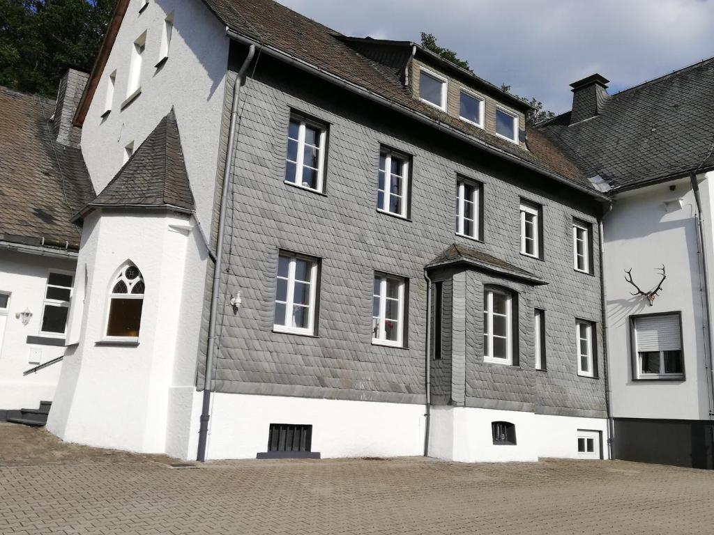 ein großes weißes Gebäude mit grauem Dach in der Unterkunft Jagdschloss Siedlinghausen in Winterberg