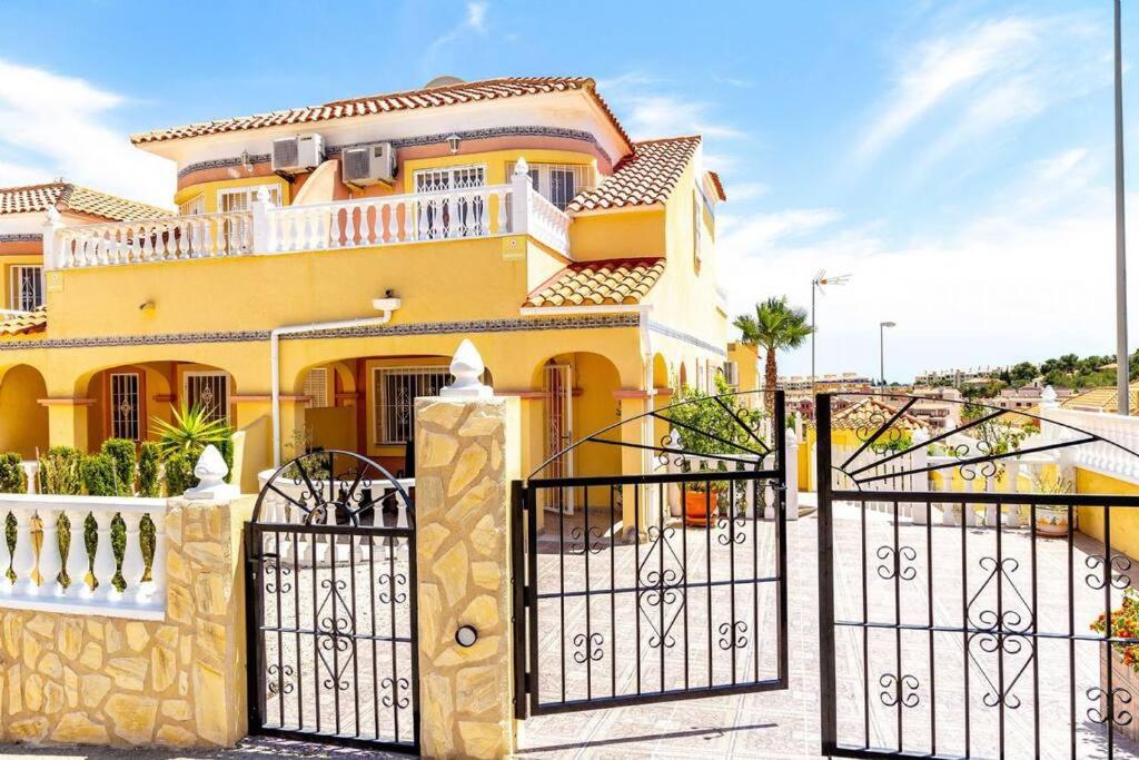 una casa amarilla con una puerta delante de ella en Fabulous 3 Bed House with 4 communal pools, en Villacosta