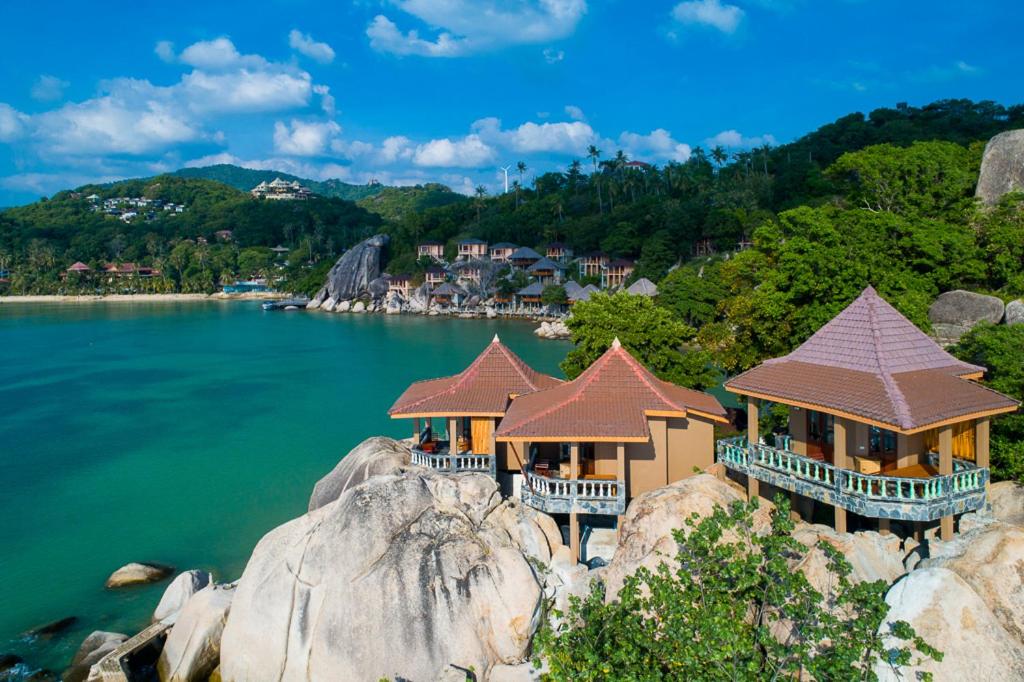 un grupo de casas sobre una roca en el agua en Koh Tao Relax Freedom Beach Resort, en Ko Tao