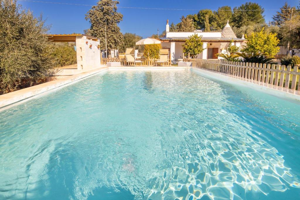 una piscina con acqua blu di fronte a una casa di Villa Acqua Azzurra a Ceglie Messapica