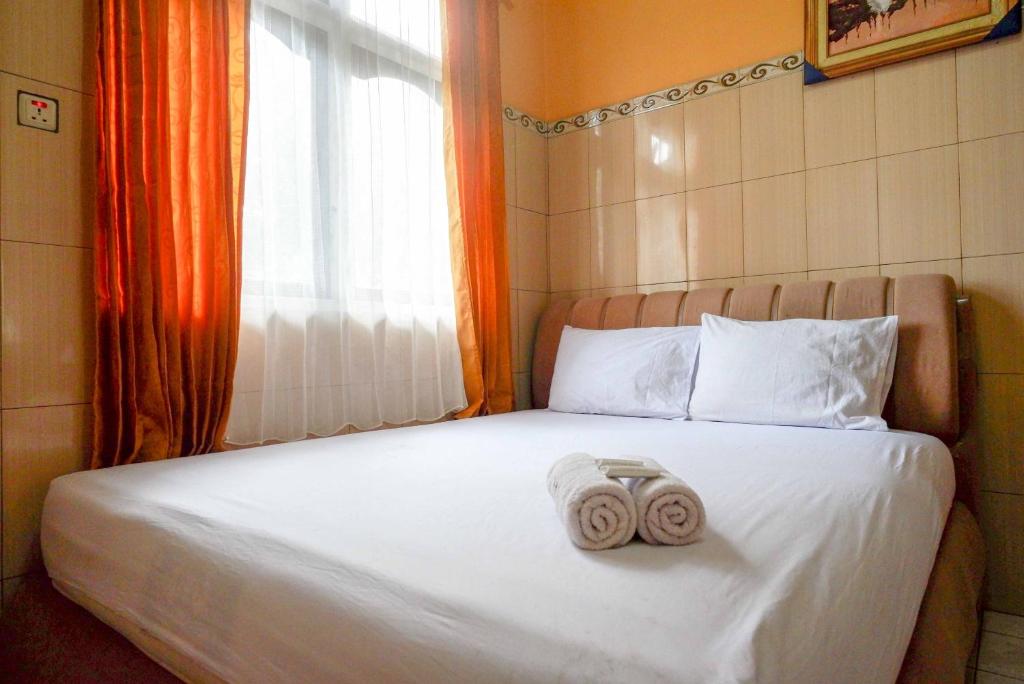 Postel nebo postele na pokoji v ubytování Urbanview Hotel Anugrah Kendal by RedDoorz