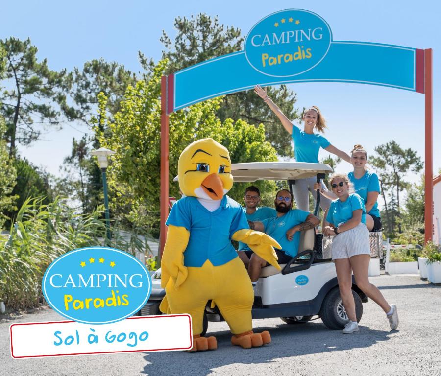 a large yellow duck mascot standing in front of a golf cart at CAMPING PARADIS Sol à Gogo in Saint-Hilaire-de-Riez