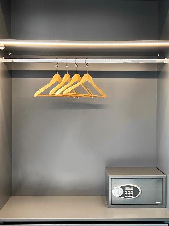 a closet with a shelf with baseball bats and a microwave at ICON Urban Living in Thessaloniki