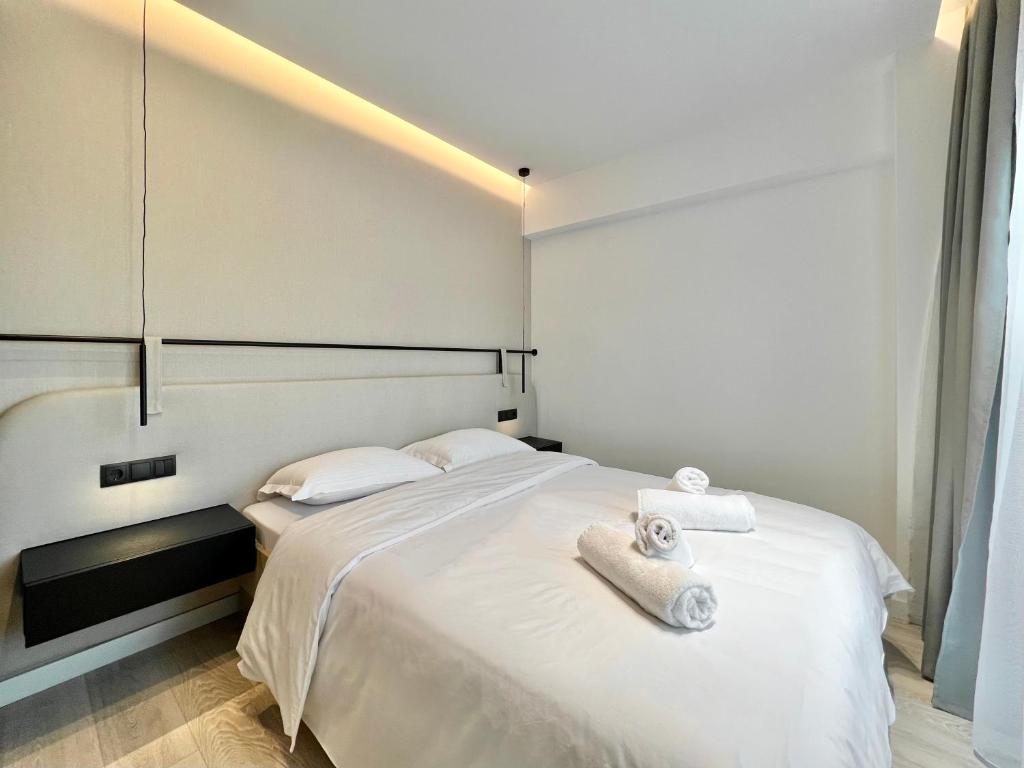 a bedroom with a white bed with towels on it at ICON Urban Living in Thessaloniki