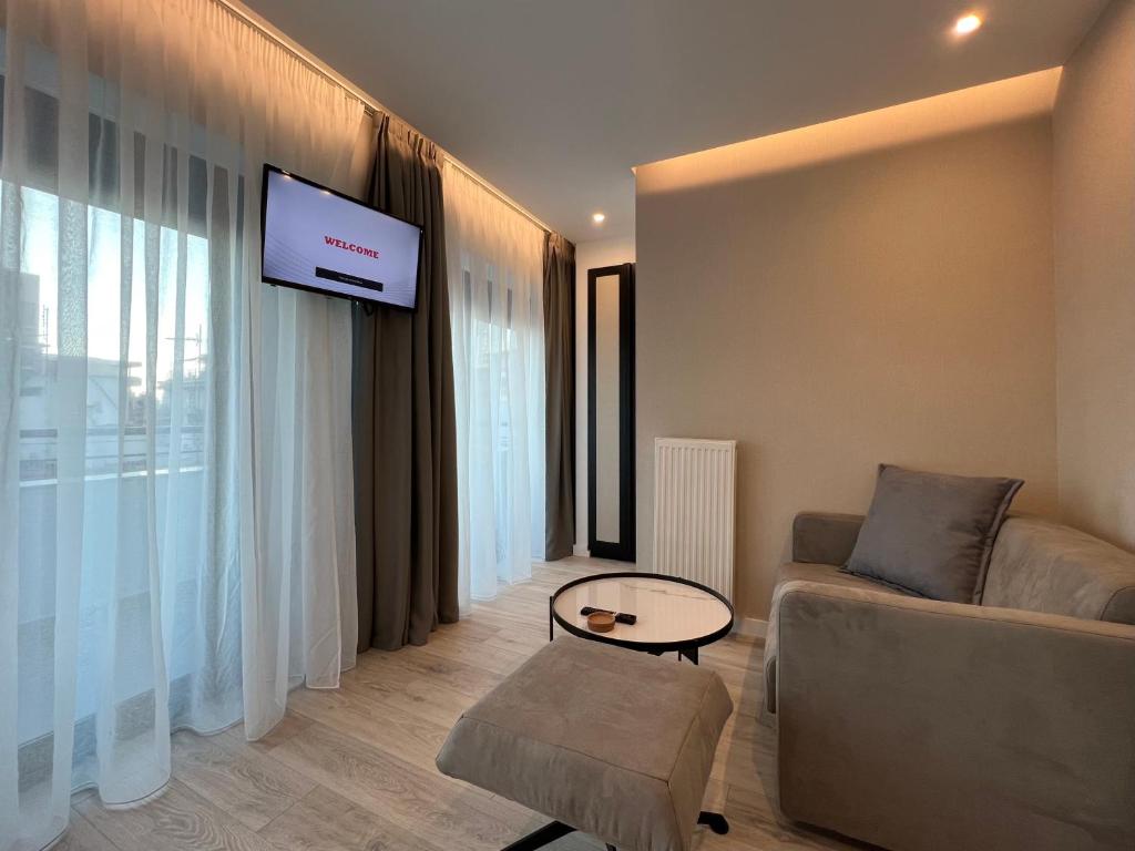 a living room with a couch and a tv on a wall at ICON Urban Living in Thessaloniki
