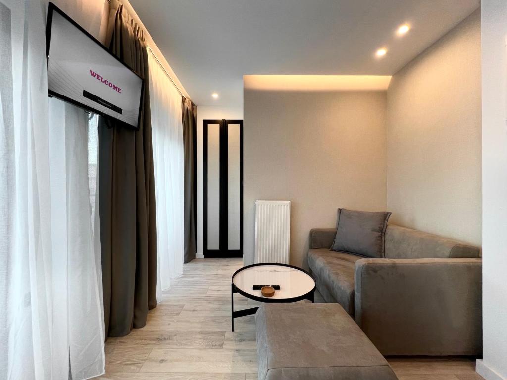 a living room with a couch and a flat screen tv at ICON Urban Living in Thessaloniki