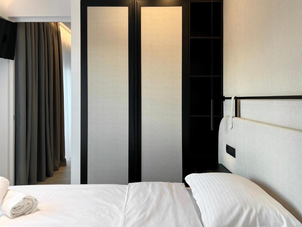 a bedroom with a white bed and a mirror at ICON Urban Living in Thessaloniki