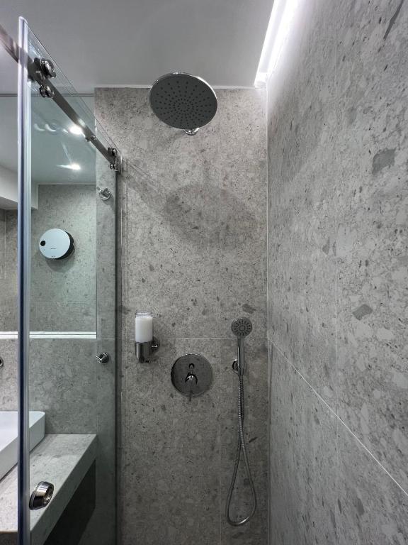 a bathroom with a shower with a glass door at ICON Urban Living in Thessaloniki