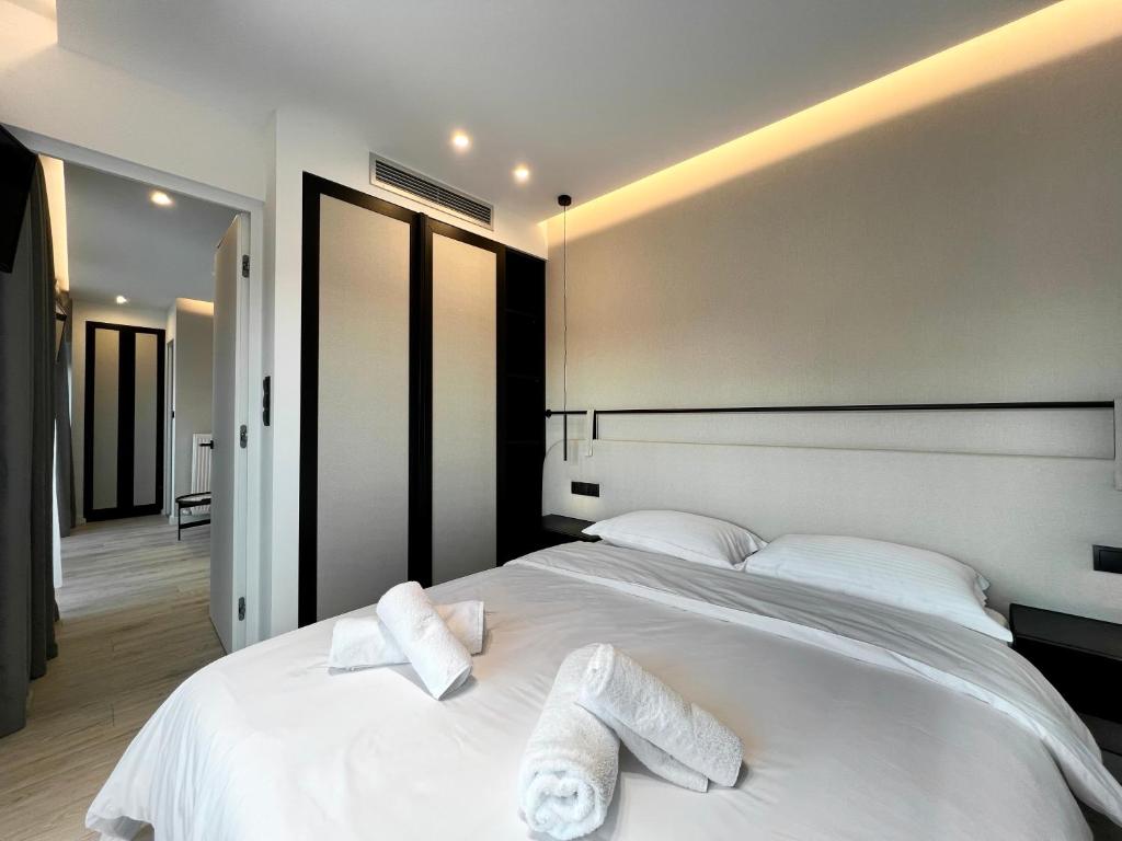 a bedroom with a large white bed with towels on it at ICON Urban Living in Thessaloniki