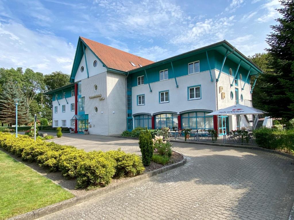 um grande edifício branco com um telhado verde em gut-Hotel Pommernhotel Barth em Barth