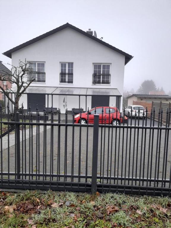 un camión rojo estacionado frente a una casa blanca en Berlin - Schönefeld grüne Wohnung en Schönefeld