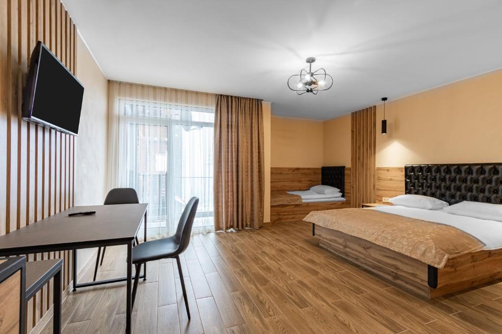 ein Hotelzimmer mit einem Bett und einem Schreibtisch mit einem Computer in der Unterkunft Milana SPA & Hotel - SPA included in Bukowel