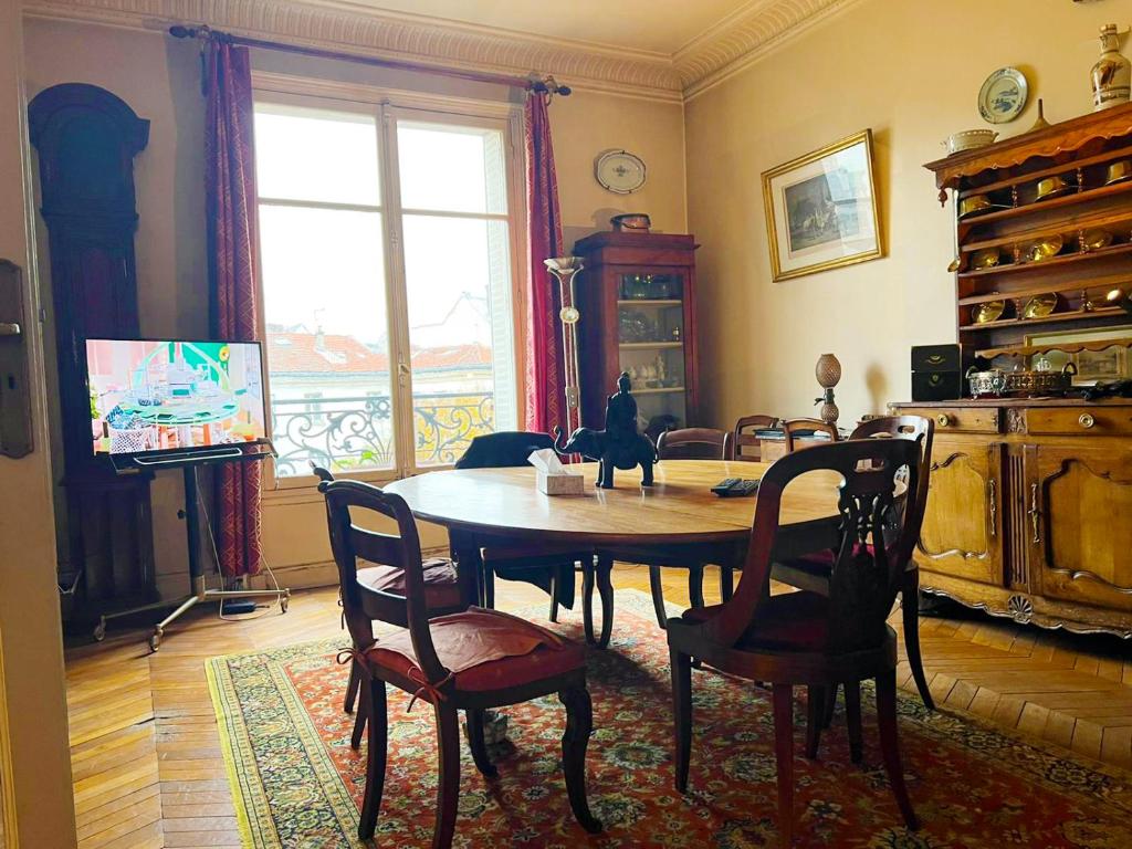 - une salle à manger avec une table et des chaises en bois dans l'établissement beautiful flat in the center of Paris 6 th district, à Paris