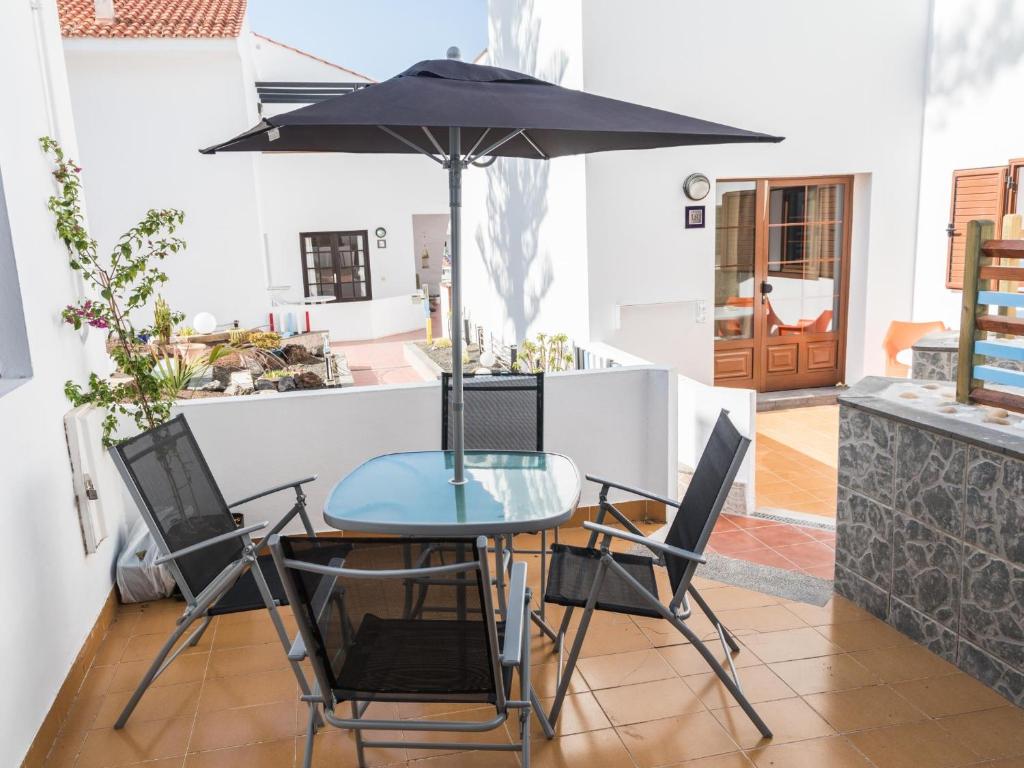 a table and chairs with an umbrella in a kitchen at SUNSET RUBY ,1 Bedroom, SWIMMING POOL in Caleta De Fuste