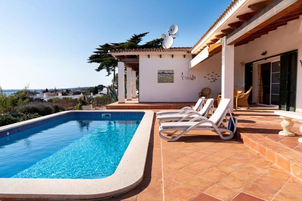 een villa met een zwembad en een patio bij VILLA BINIBECA LIFE in Binibeca