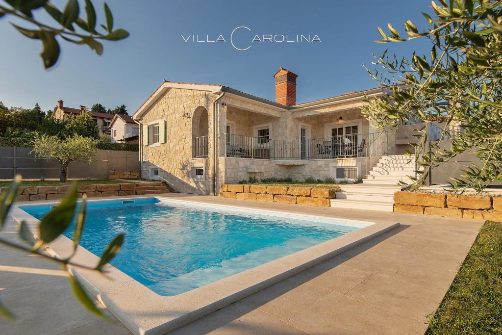 a swimming pool in front of a house at Villa Carolina in Izola