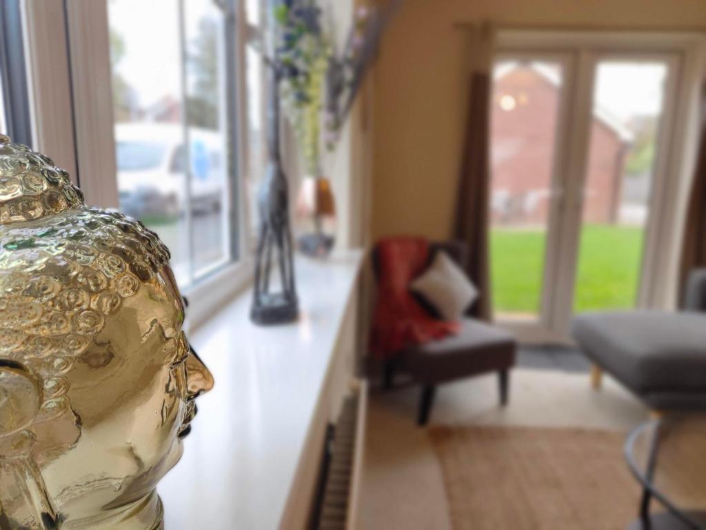 - un salon avec une statue du visage sur un comptoir dans l'établissement Lakeside-Dakota 3bed house 2bath parking M27 J5 Southampton Airport sleeps 6, à Eastleigh