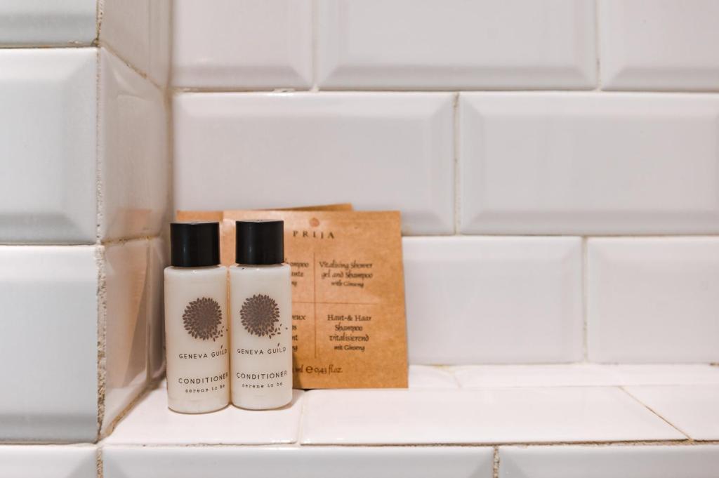 two bottles ofodorizers sitting on a shelf in a bathroom at Nikis Collection Trastevere in Rome