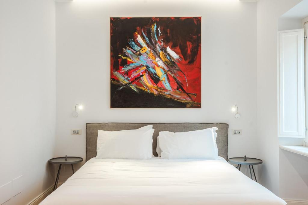 a bedroom with a bed with a painting above it at Nikis Collection Trastevere in Rome