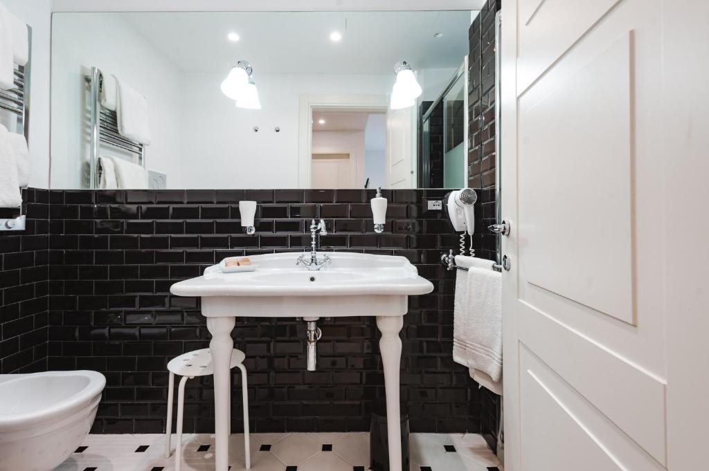 a bathroom with a white sink and a toilet at Nikis Collection Trastevere in Rome