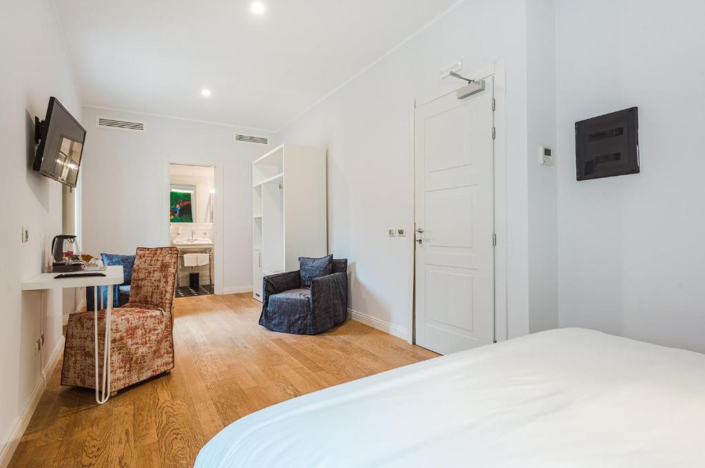 a bedroom with a bed and a desk and chairs at Nikis Collection Trastevere in Rome