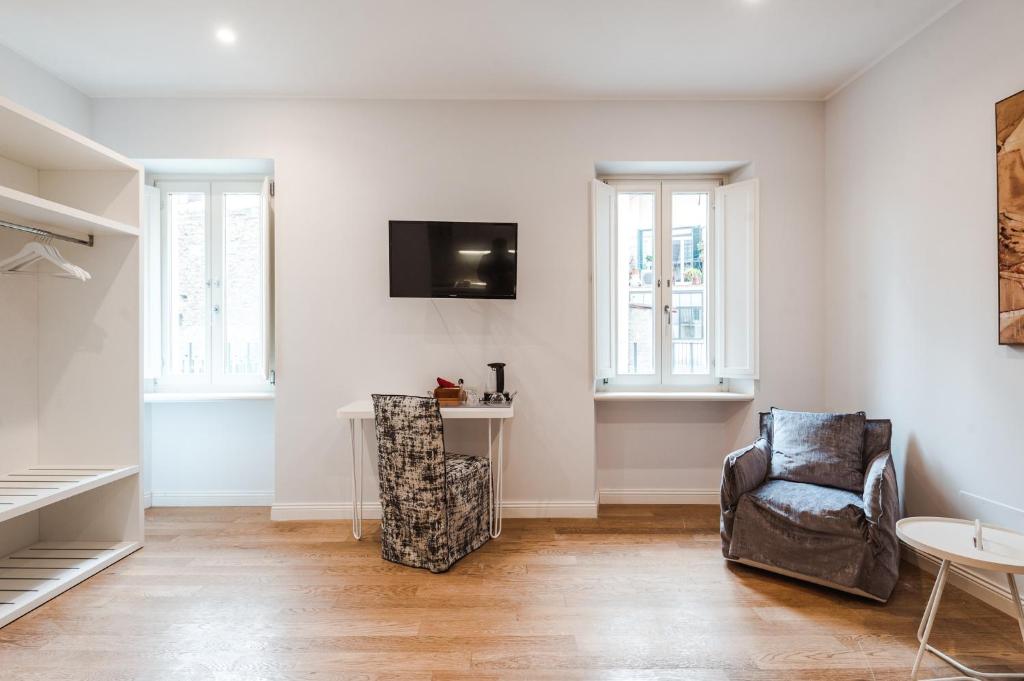 a living room with a chair and a tv on the wall at Nikis Collection Trastevere in Rome
