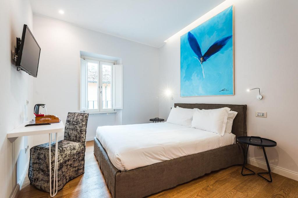 a bedroom with a bed and a desk and a tv at Nikis Collection Trastevere in Rome