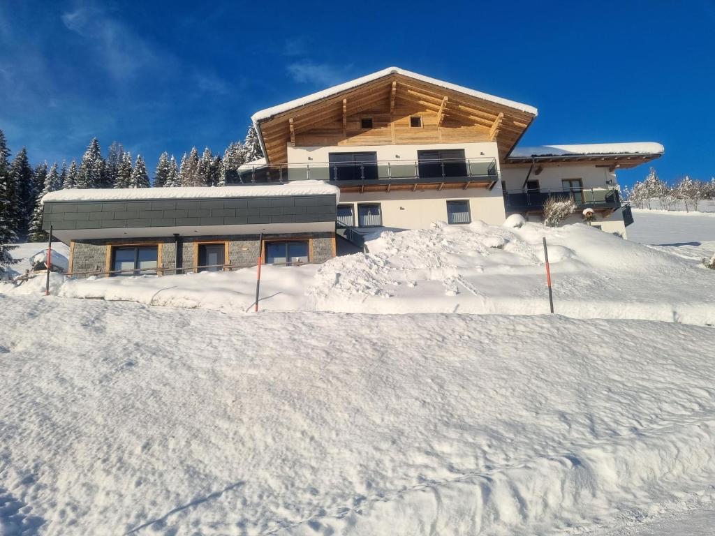 ein Haus auf einem schneebedeckten Hügel in der Unterkunft Appartement Fritzl in Wagrain