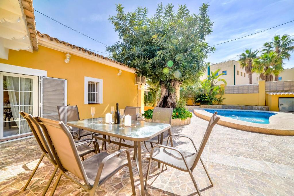 a patio with a table and chairs and a pool at Villa Alexandra - PlusHolidays in Calpe
